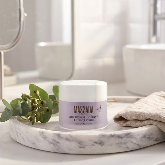 Massada Amethyst & Collagen Lifting Cream 50 ml sobre una bandeja de mármol, junto a ramas verdes y una toalla de lino