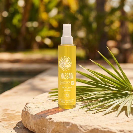 Massada Bruma Solar Body & Hair SPF 30 200 ml sobre una piedra al sol junto a una piscina y hojas verdes