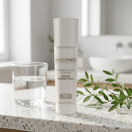 Massada Immaculate Cream Smart Bioretinol 50 ml en encimera de baño con vaso de agua y hojas verdes