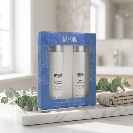 Pack Massada Limpieza Facial Ácido Hialurónico sobre bandeja de mármol en el baño, junto a hojas verdes y una toalla