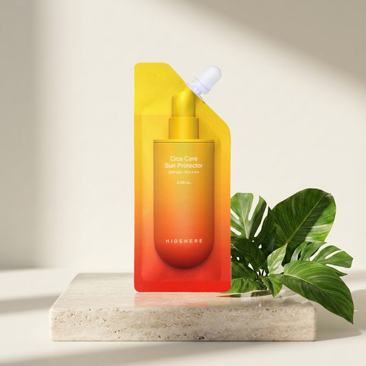 Hidehere Cica Care Sun Protector 25 ml sobre una losa de travertino, junto a hojas de monstera a la luz del sol
