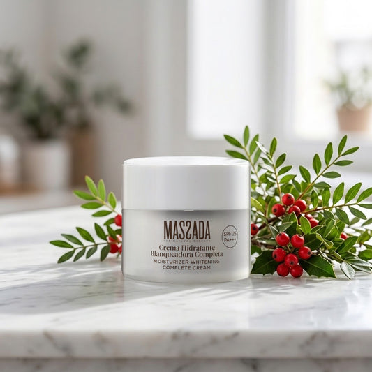 Massada Crema Hidratante Blanqueadora Completa SPF 25 50 ml sobre una encimera de mármol, junto a ramitas verdes