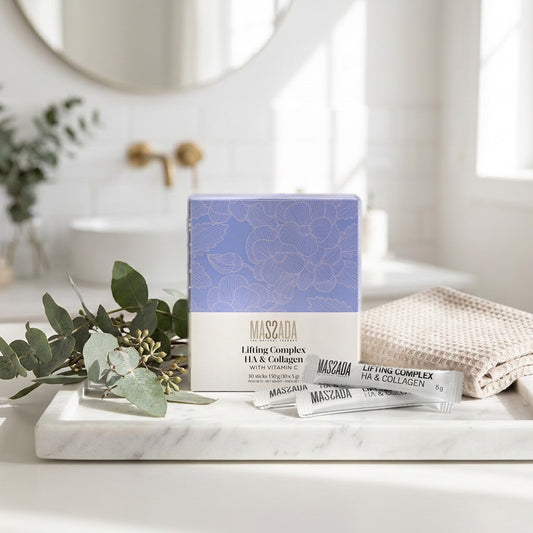 Massada Lifting Complex HA & Collagen 30 sticks en bandeja de mármol del baño, con hojas verdes y toalla beige