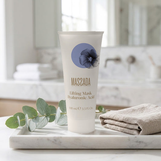 Massada Lifting Mask Hyaluronic Acid 100 ml sobre bandeja de mármol en un baño, junto a hojas verdes y una toalla