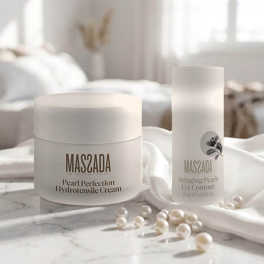 Pack Massada Pearl Perfection: crema y contorno de ojos sobre mármol blanco, junto a perlas sueltas y un paño de seda