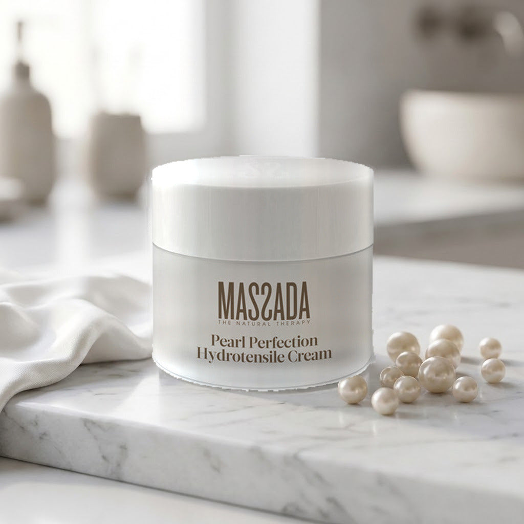 Massada Pearl Perfection Hydrotensile Cream 50 ml sobre mármol blanco con perlas y una toalla blanca