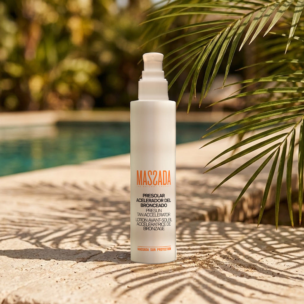 Massada Presolar Acelerador del Bronceado 200 ml sobre el borde de piedra de una piscina, junto a hojas de palmera