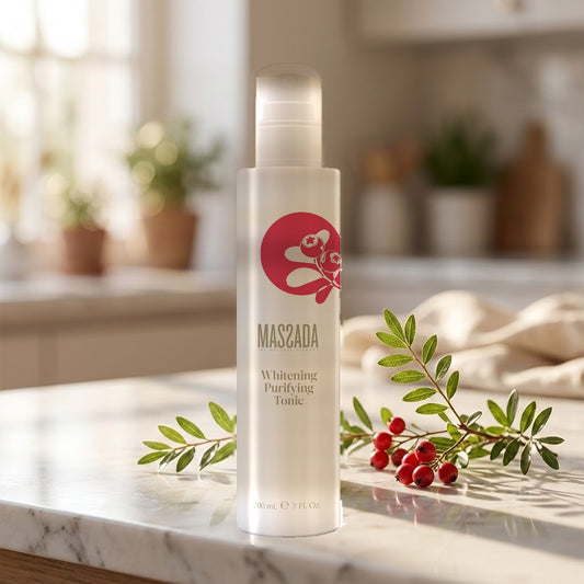 Massada Tónico Blanqueador Purificante 200 ml sobre encimera de mármol con una ramita de hojas verdes y un paño claro